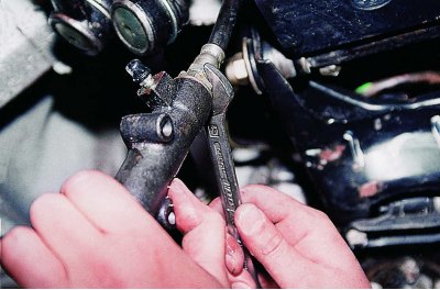 С помощта на 13 мм вложка развийте двата болта, закрепващи цилиндъра към корпуса на съединителя.