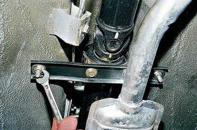 С помощта на 13 мм глава развийте двете гайки и отстранете предпазната скоба.