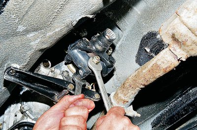 С помощта на 13 мм вложка развийте двете гайки, закрепващи напречната греда на скоростната кутия…