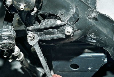 В отделението на двигателя, през отвора в калника, използвайте 17 mm гаечен ключ, за да развиете…