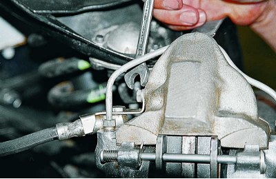 Вынимаем из кронштейна тормозной шланг, а на тормозную трубку надеваем защитный колпачок прокачного…