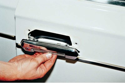 С помощта на гаечен ключ 8 mm развийте двете гайки, закрепващи външната дръжка на вратата...