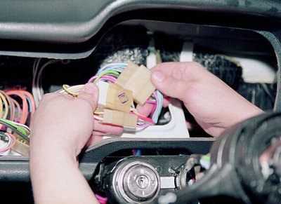 Внутри приборной панели разъединяем соединительные колодки жгута подвода напряжения к подрулевым…