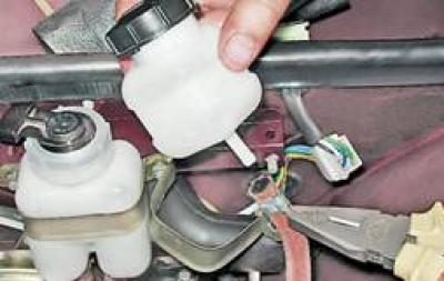 5. Ослабляем плоскогубцами ленточный хомут и снимаем шланг со штуцера бачка.