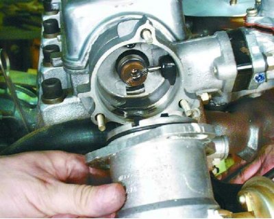 15. Отверните три гайки крепления распределителя зажигания. Снимите кронштейн крепления…