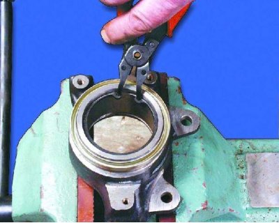 5. Using a mandrel, press the bearing out of the steering knuckle.