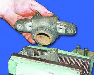 6. Strângeți etrierul într-o menghină și scoateți cele două șuruburi Allen care fixează cilindrul…