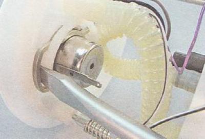 3. Шлицевой отверткой поддеваем и вынимаем пружинный фиксатор регулятора давления топлива.