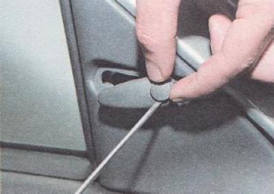 2. С помощта на отвертка с тънък шлиц отстранете щепсела от дръжката за управление на огледалото.