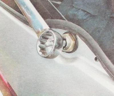 12. Az ajtó kívülről egy 24 mm-es villáskulccsal csavarja ki a motor reduktor rögzítőanyáját.