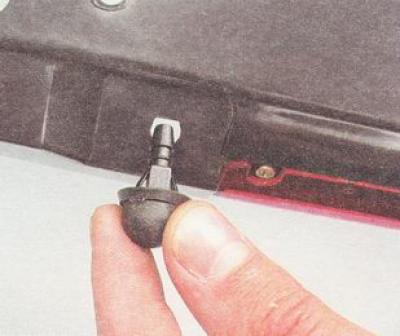 2. Сжав два фиксатора, снимаем форсунку с основания спойлера.