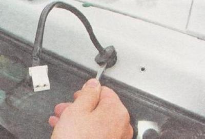 14. Csavarhúzóval nyomja be a tömítést a csomagtérfedél lyukába, és a nyíláson keresztül húzza be a…