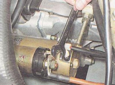 5. Using a 13 mm wrench, unscrew the nut securing the starter power cable tip.