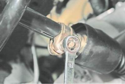 10. Kulccsal 13 mm-rel lecsavarjuk a kötőcsavar anyáját, és meglazítjuk a bilincset.