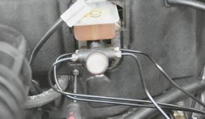 5. Крестовой отверткой отворачиваем винт, соединяющий части обивки моторного отсека.