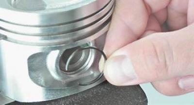 2. Шилом поддеваем и вынимаем из проточек стопорные кольца поршневого пальца.