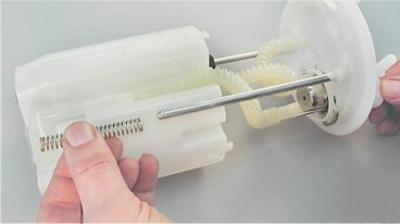 4. Выведя направляющие крышки из корпуса топливного модуля, снимаем пружину.