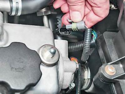 2. Освободив фиксатор, отсоединяем колодку проводов от датчика положения распределительного вала.