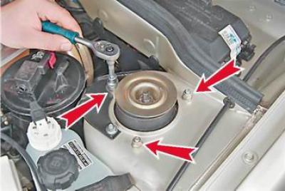 5. С гаечен ключ с 13 мм с помощта на дълбоко гнездо развийте трите гайки, закрепващи горната опора…