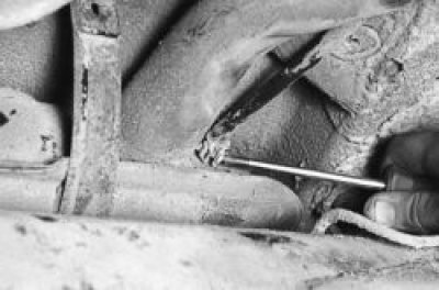 13. Holding the fuel tank, unscrew the two bolts securing the pressure bands…
