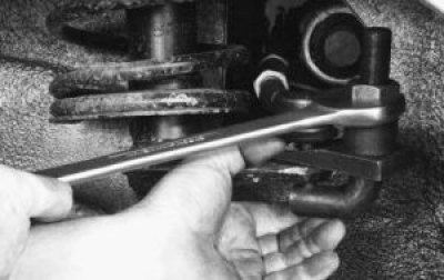 9. С помощью съемника выпрессуйте палец шарового шарнира рулевой тяги из поворотного рычага стойки.