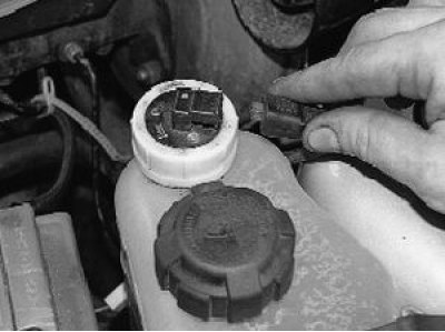 3. Отверните гайку крепления датчика к корпусу расширительного бачка…