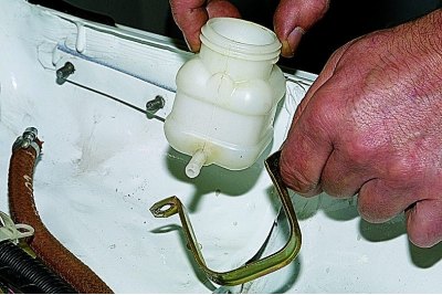 Za pomocą klucza płaskiego 10 mm odkręć dwie nakrętki mocujące obejmę zbiornika do nadwozia…