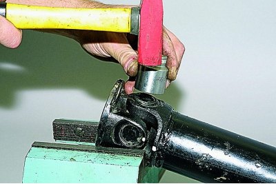 При отсутствии съемника опираем вилку фланца карданного вала на опору (губки тисков)…