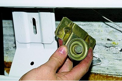 Koristeći utičnicu od 10 mm, odvrnite montažni vijak nosača zateznog valjka..