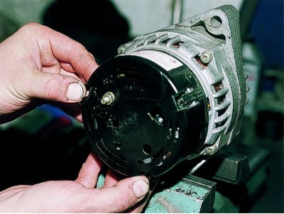 Using a 13 mm spanner, unscrew the nut of the generator lower mounting bolt to the bracket on the…