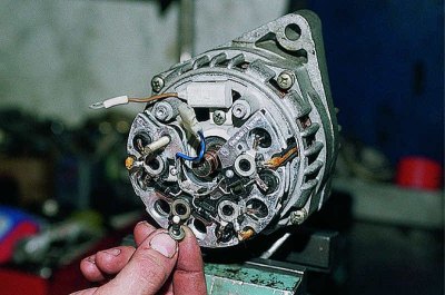 Using a Phillips screwdriver, unscrew the screw securing the rectifier block and the three screws…
