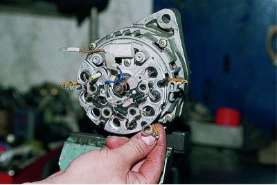 Insulating washers are placed on the screws securing the ends of the stator windings.