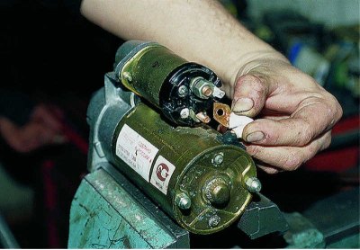 Using a 13 mm spanner, unscrew the nut on the lower terminal of the traction relay.